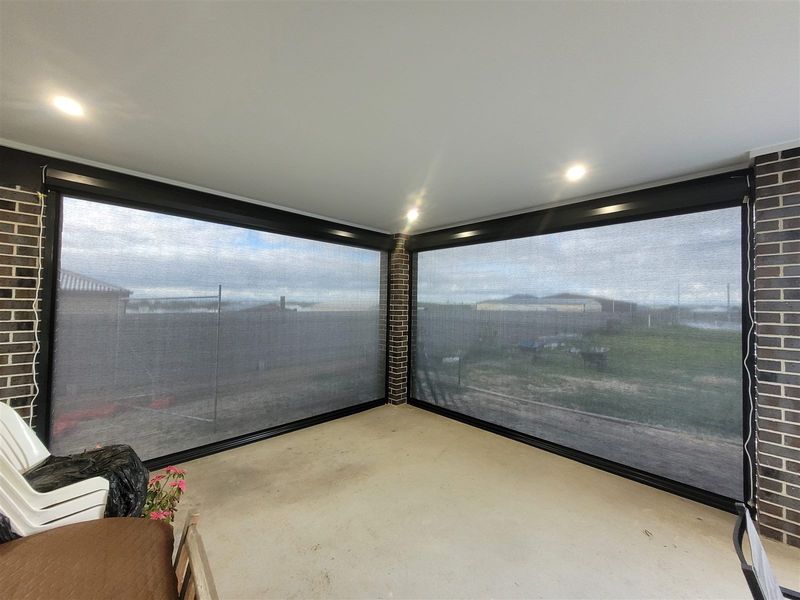 Alfresco area enclosed by outdoor blinds with outdoor furniture