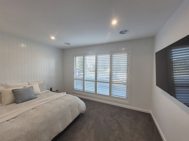 White plantation shutters across bedroom windows