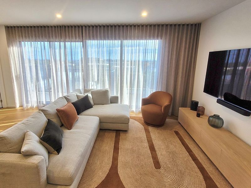 S-fold sheer and blockout curtains behind a lounge in a Brighton living room