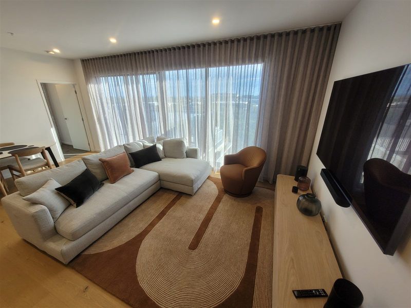 Floor-to-ceiling sheer curtains in a bright apartment living area