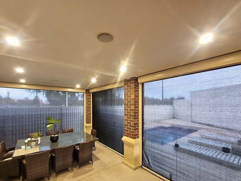Mesh zip track blinds around an alfresco dining area beside a pool in Seaford